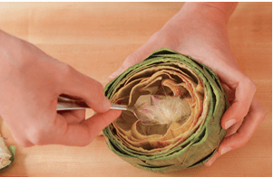 Removing the artichoke heart with a spoon. 