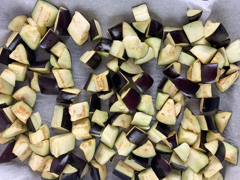 Cubed eggplants on a lined baking tray. 