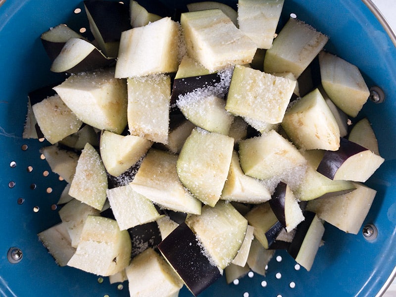Eggplant cubes with salt in a colander. 