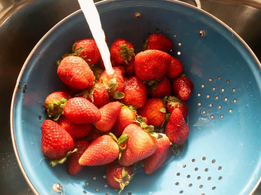 washing the strawberries for berry salad