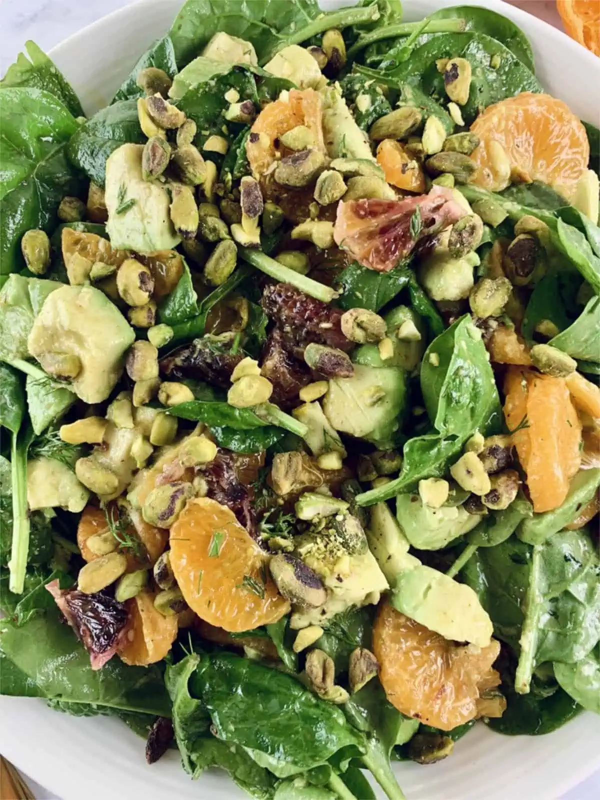 A close-up of spinach and mandarin salad.