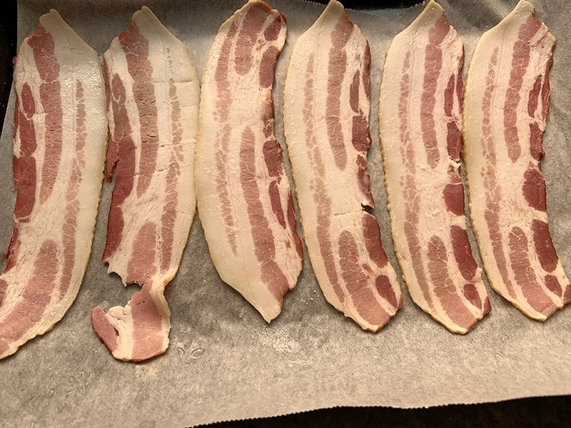 RAW BACON STRIPS ON  OVEN TRAY