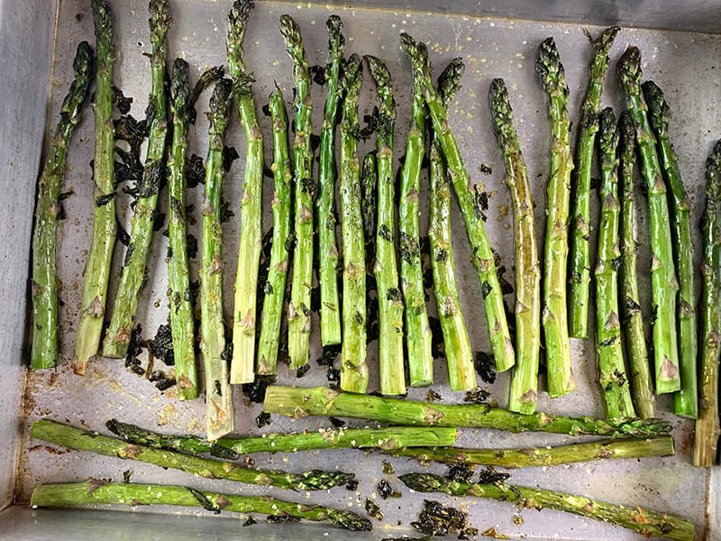 Roasted asparagus spears on an oven tray. 