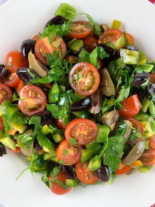 A close up of tomato and olive salad.