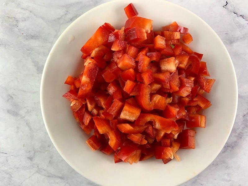 Diced red capsicum or peppers on a white plate. 