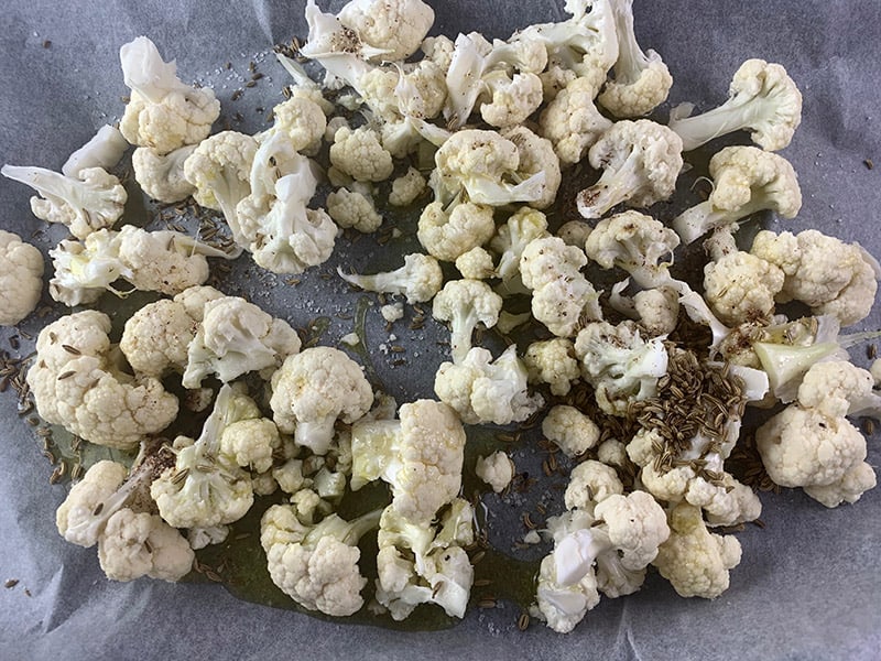 CAULIFLOWER FLORETS WITH SPICES AND OIL ON BAKING TRAY