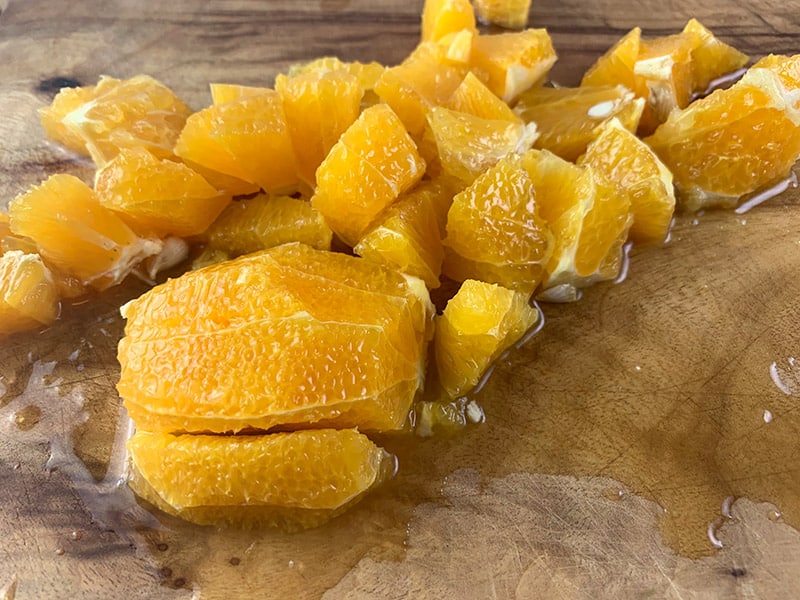 A close up of a segmented orange that is diced. 
