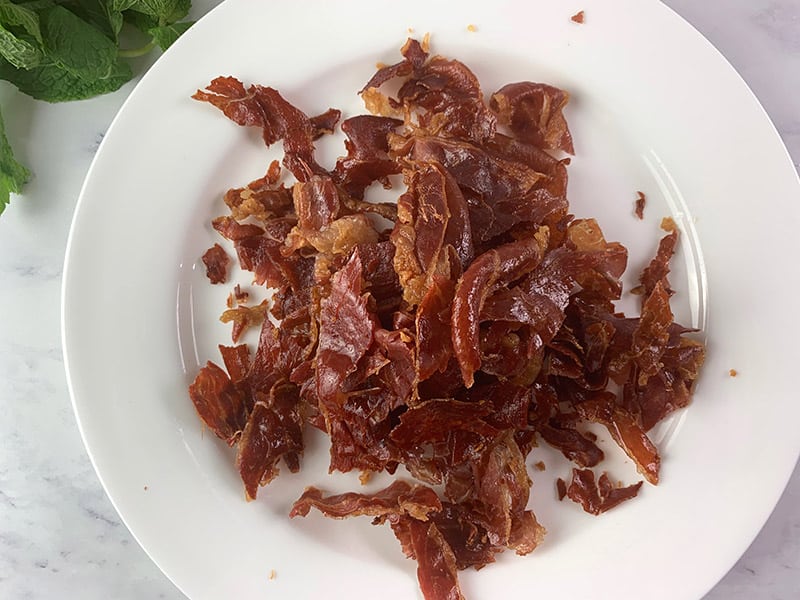Crumbled prosciutto on a plate.