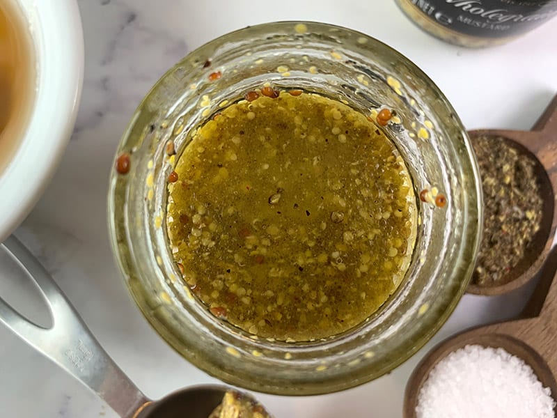 An aerial view of honey mustard dressing in a glass jar. 