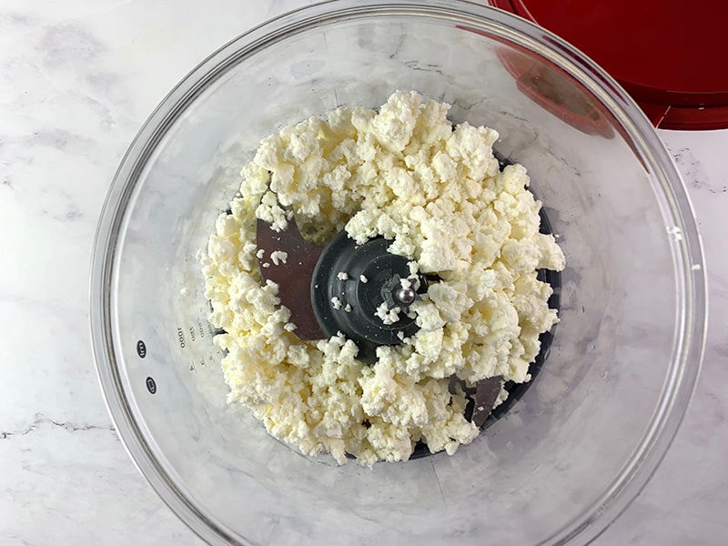 CRUMBLED FETA IN A FOOD PROCESSOR WAITING TO BE PULSED