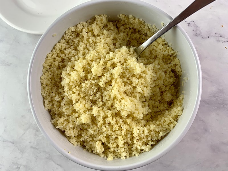 FLUFFING COOKED COUSCOUS WITH A FORK 