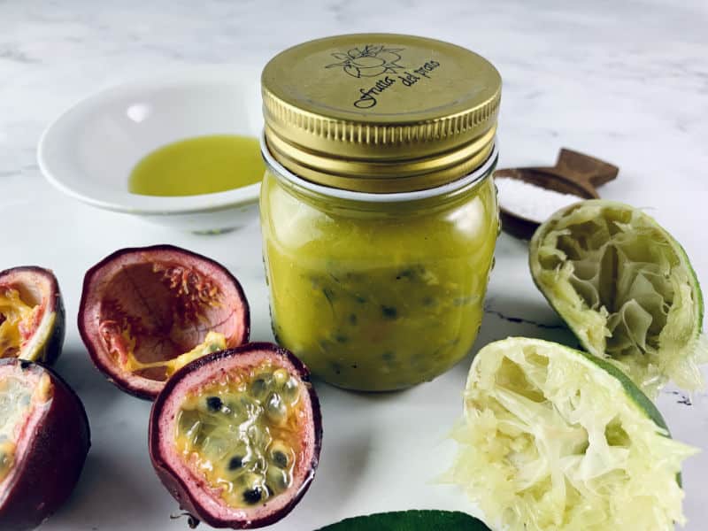 Shaken Passion Fruit Dressing in a glass jar with ingredients scattered around.