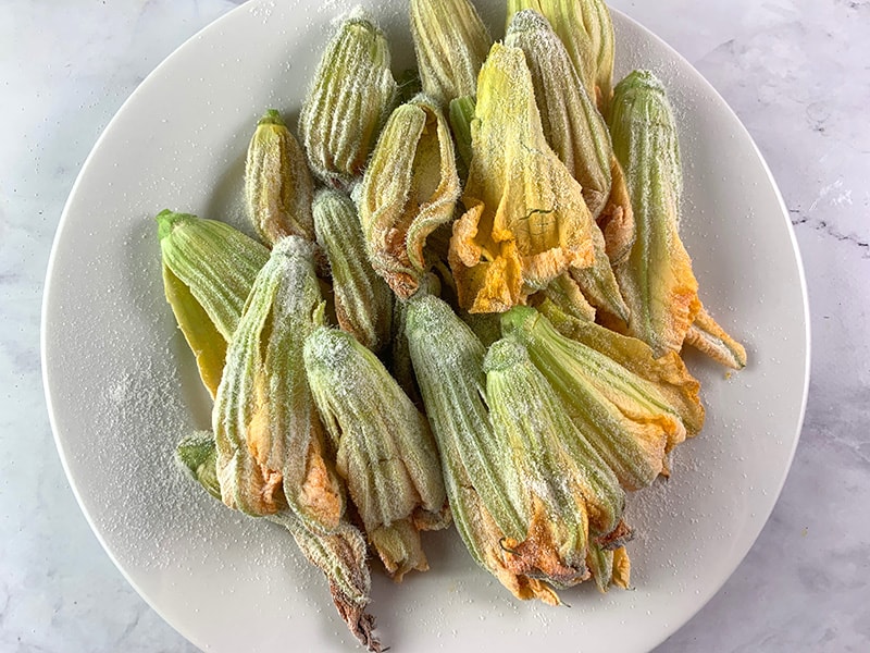Dredged Zucchini flowers on a plate.