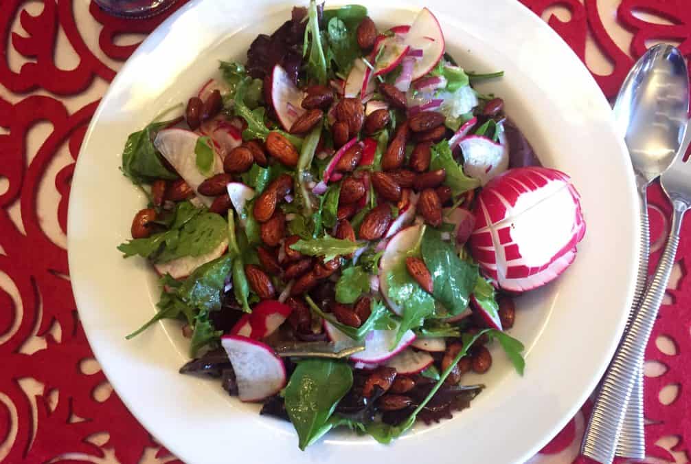 SPRING RADISH SALAD WITH ALMONDS AND ARUGULA IN AERIAL VIEW