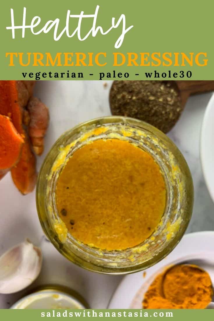 OVERHEAD VIEW OF SHAKEN TURMERIC DRESSING IN A GLASS JAR WITH TURMERIC, GARLIC, SALT AND PEPPER ON THE SIDE AND TEXT OVERLAY