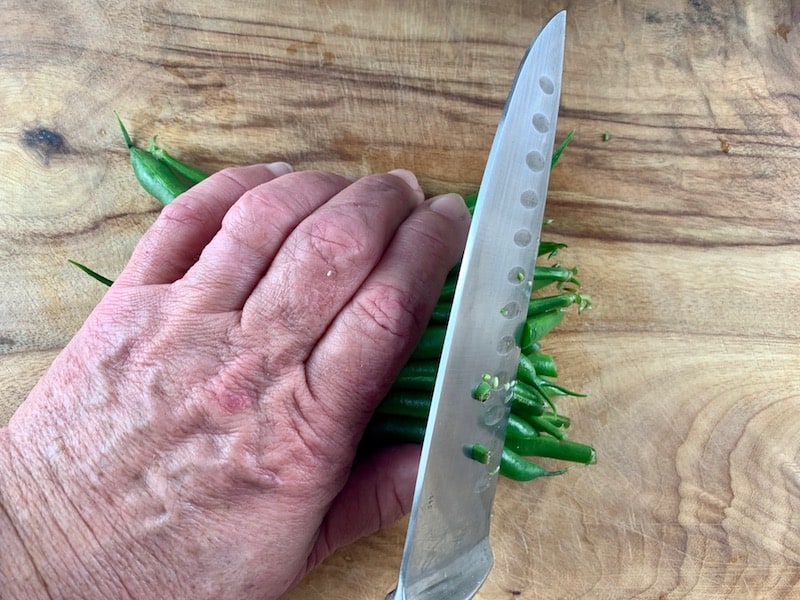 LINING UP GREEN BEANS TO CUT OFF ENDS