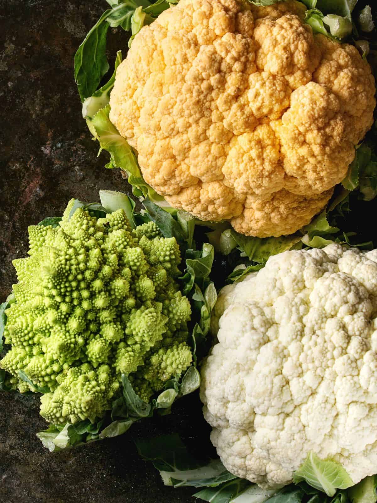 white, orange & romanesco cauliflower on a dark background