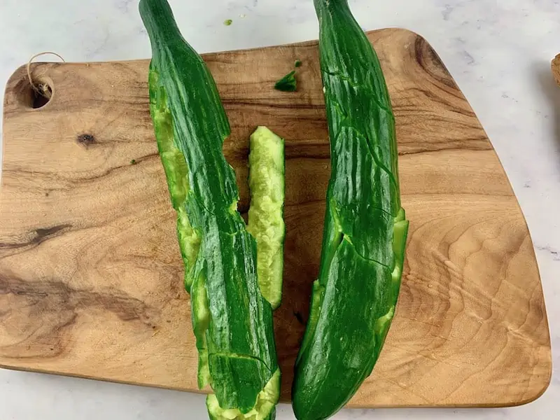 SMASHED CUCUMBERS ON WOODEN BOARD