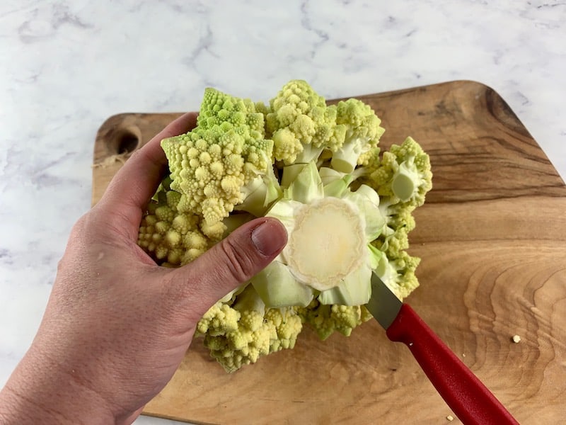 REMOVING ROMANESCO CORE WITH KNIFE ON WOODEN BOARD
