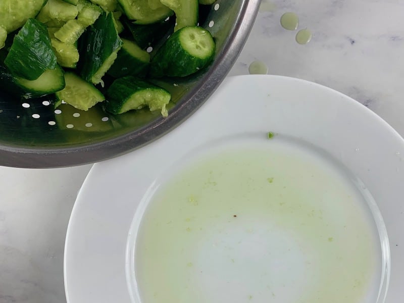 DRAINING SALTED CUCUMBERS IN COLANDER WITH PLATE