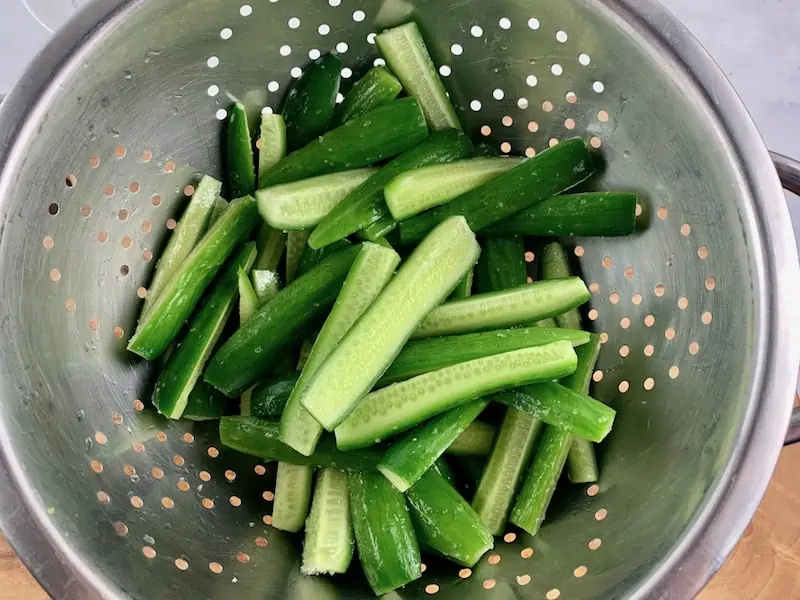 SALTED CUKES IN A STAINLESS STEEL COLANDER