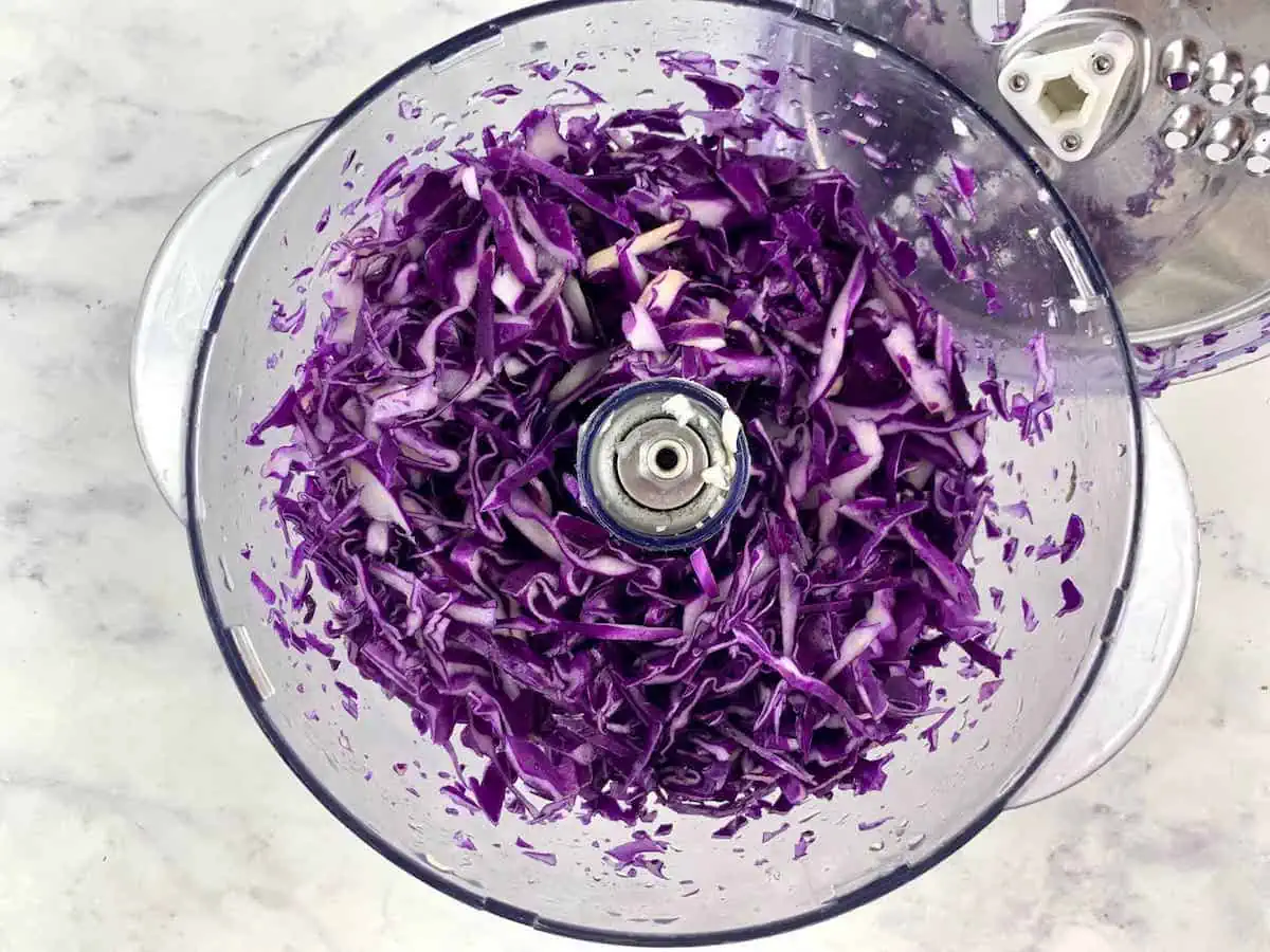 Shredded red cabbage in food processor.