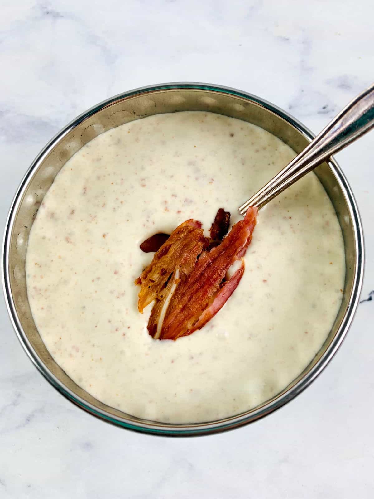 CREAMY BACON DRESSING IN A SILVER BOWL WITH SPOON