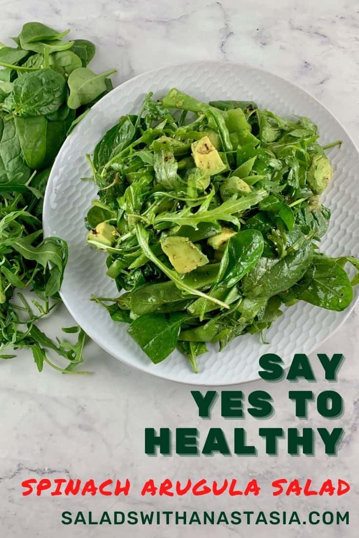 SPINACH ARUGULA SALAD ON A WHITE PLATE WITH GREENS SCATTERED AROUND & text overlay
