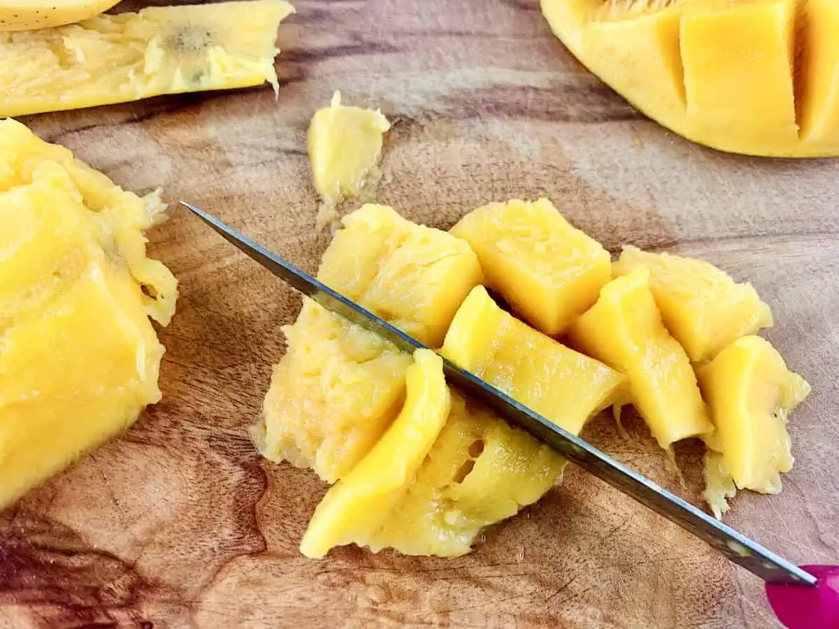 DICING MANGO FLASH ON A WOODEN BOARD WITH A KNIFE