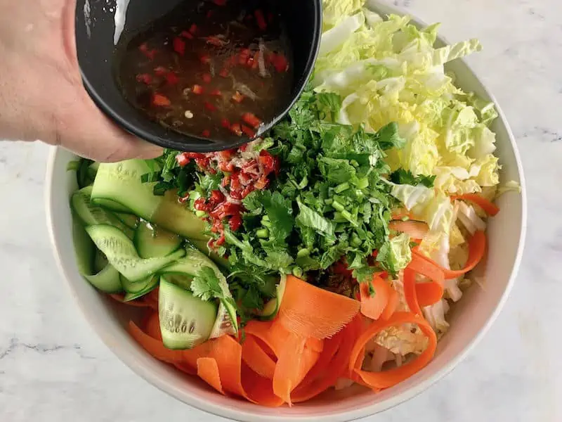POURING DRESSING OVER VIETNAMESE BEEF SALAD INGREDIENTS