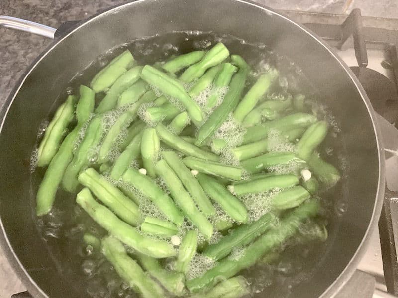 GREEN BEANS BOILING IN POT ON STOVE