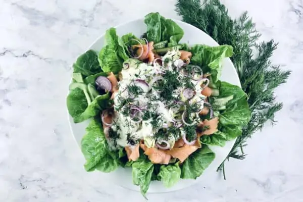 Smoked Salmon Avocado Salad on a white platter with fresh dill on top right corner.
