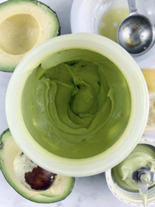 Blitzed avocado mayo in blender with ingredients scattered around.