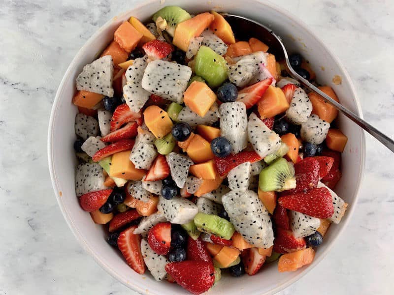 MIXING DRAGON FRUIT SALAD WITH DRESSING TO COMBINE