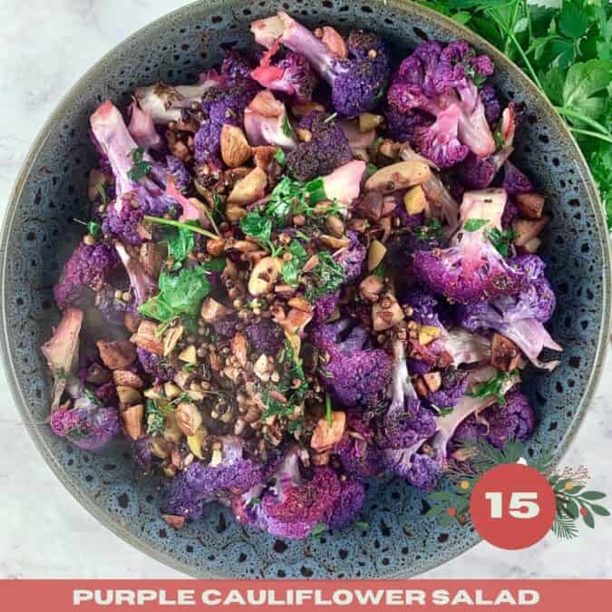 Purple cauliflower salad in a dark grey bowl with parsley on the side with a Xmas text overlay.