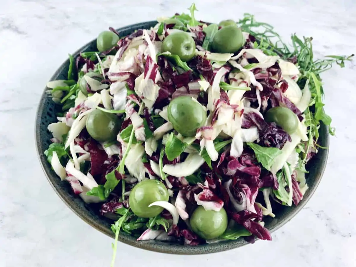 Tri Color Salad in a dark grey bowl with tarragon springs on top right corner.