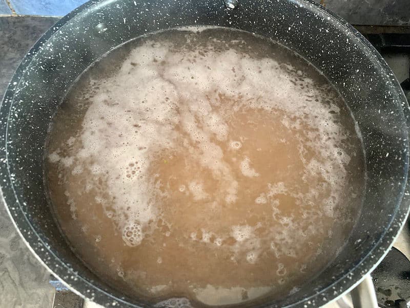 Rinsed barley with water in a pot on the stove.