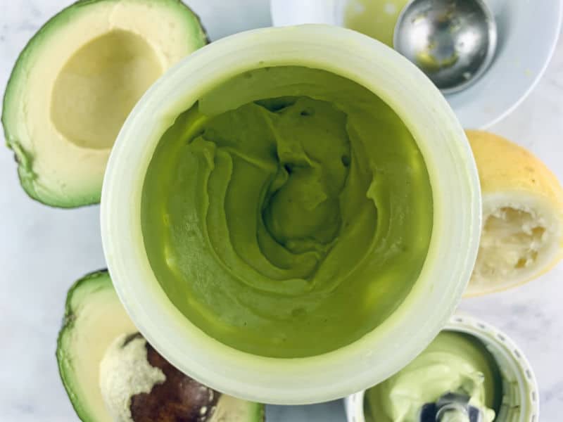 Blitzed avocado mayo in blender with ingredients surronding it.