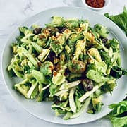 Chilean Celery Avocado Salad on a white plate with celery stalks and paprika on the side.