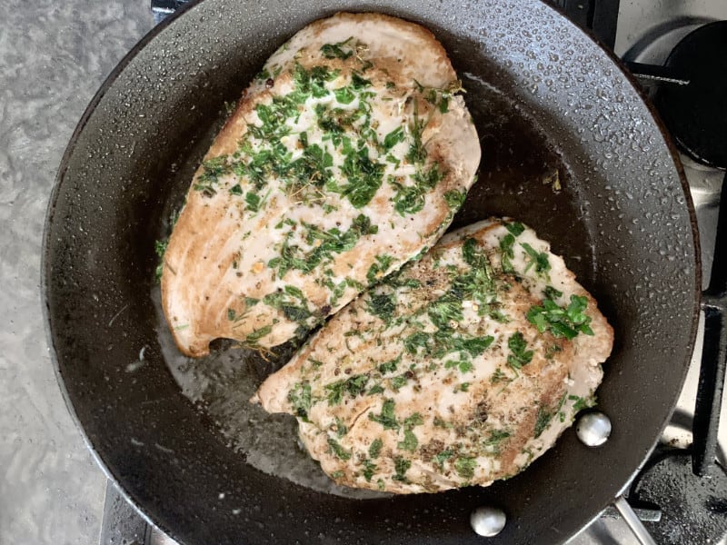 Cooked tuna steaks in pan.