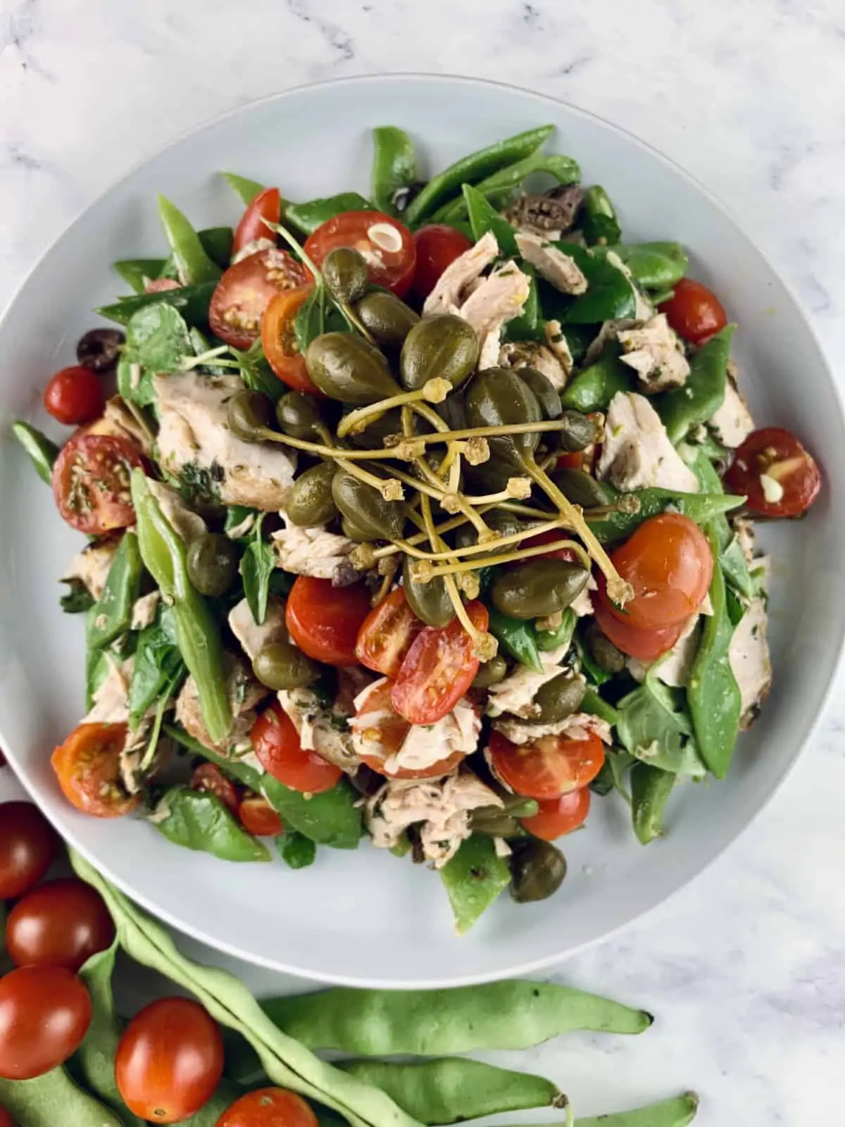 CLOSE UP OF GRILLED TUNA SALAD WITH FLAT BEANS, CAPERBERRIES AND CHERRY TOMATOES