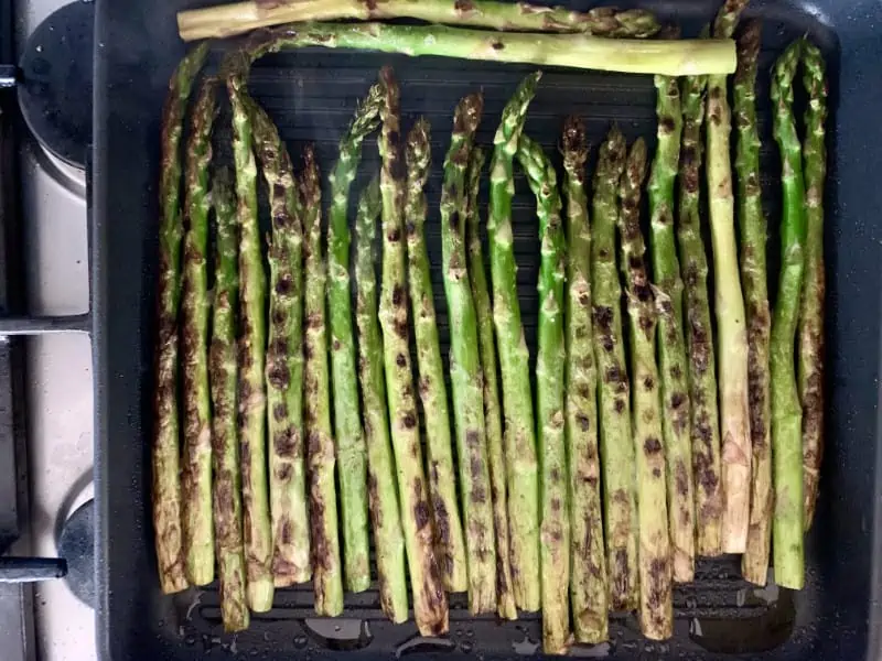 Grilled asparagus spears in grill pan.