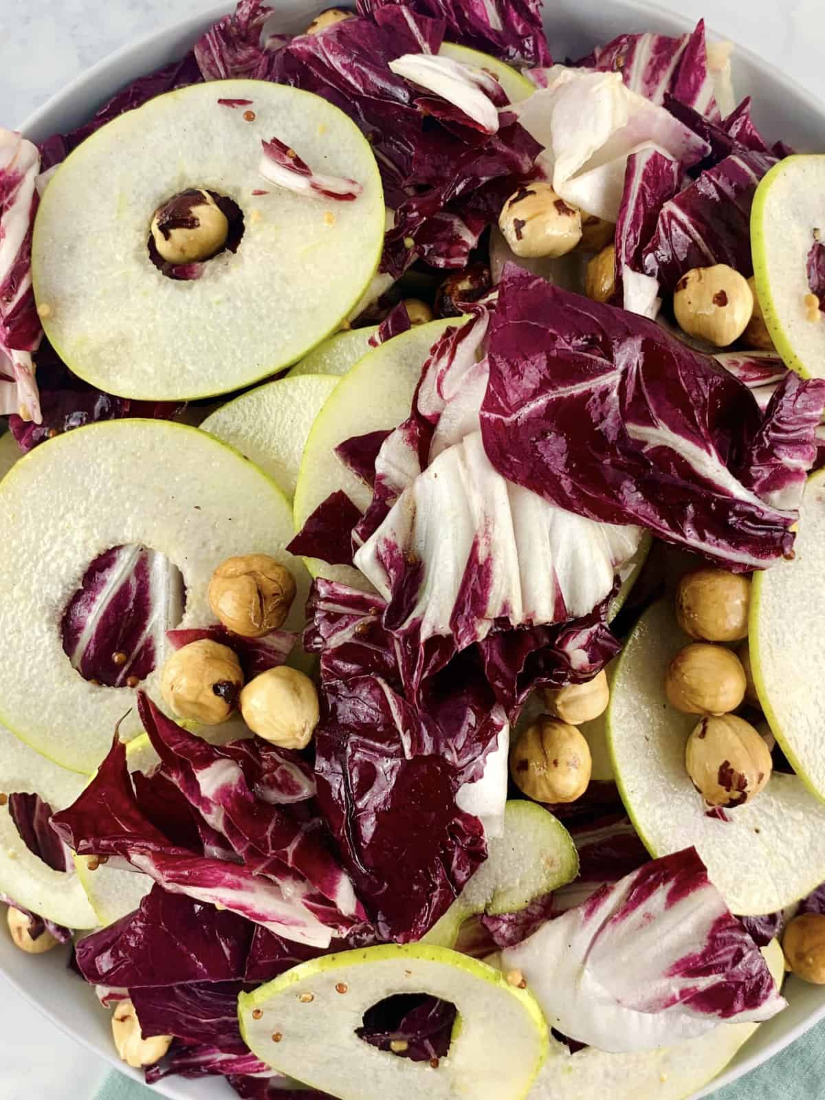 A close-up of Radicchio and pear salad in a white bowl.