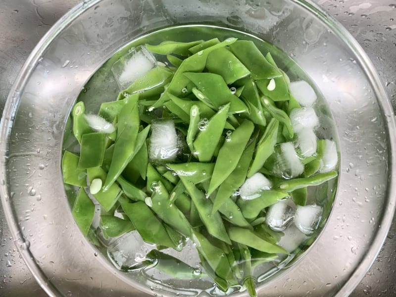 Flat beans in an ice-water bath.