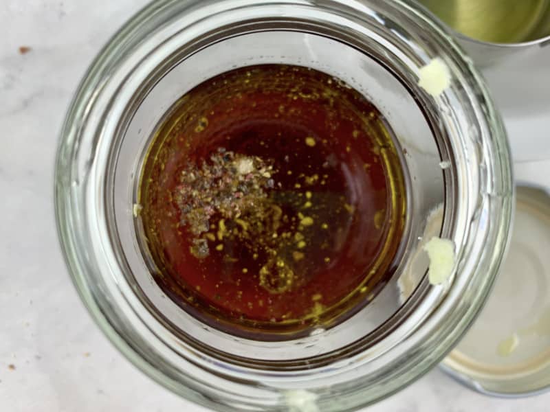 Red wine vinegar dressing ingredients in a glass jar.
