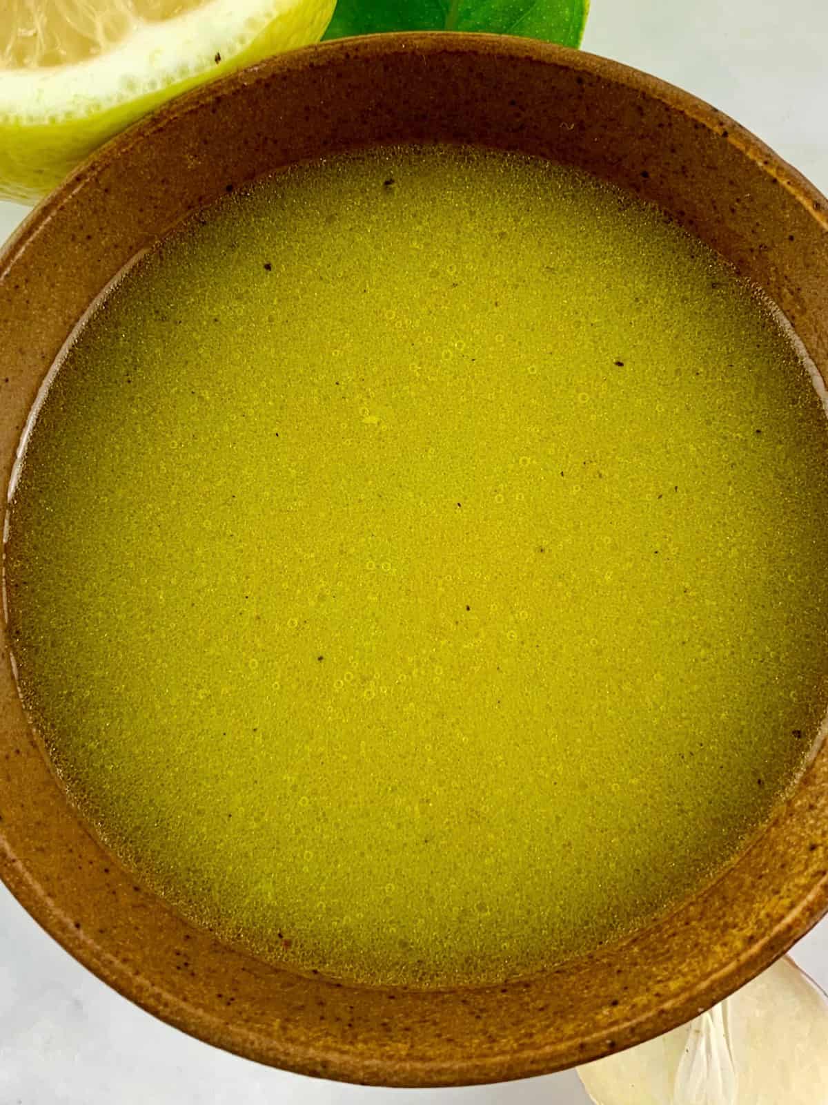 A close up of Lemon Garlic Vinaigrette in a Stone Bowl.