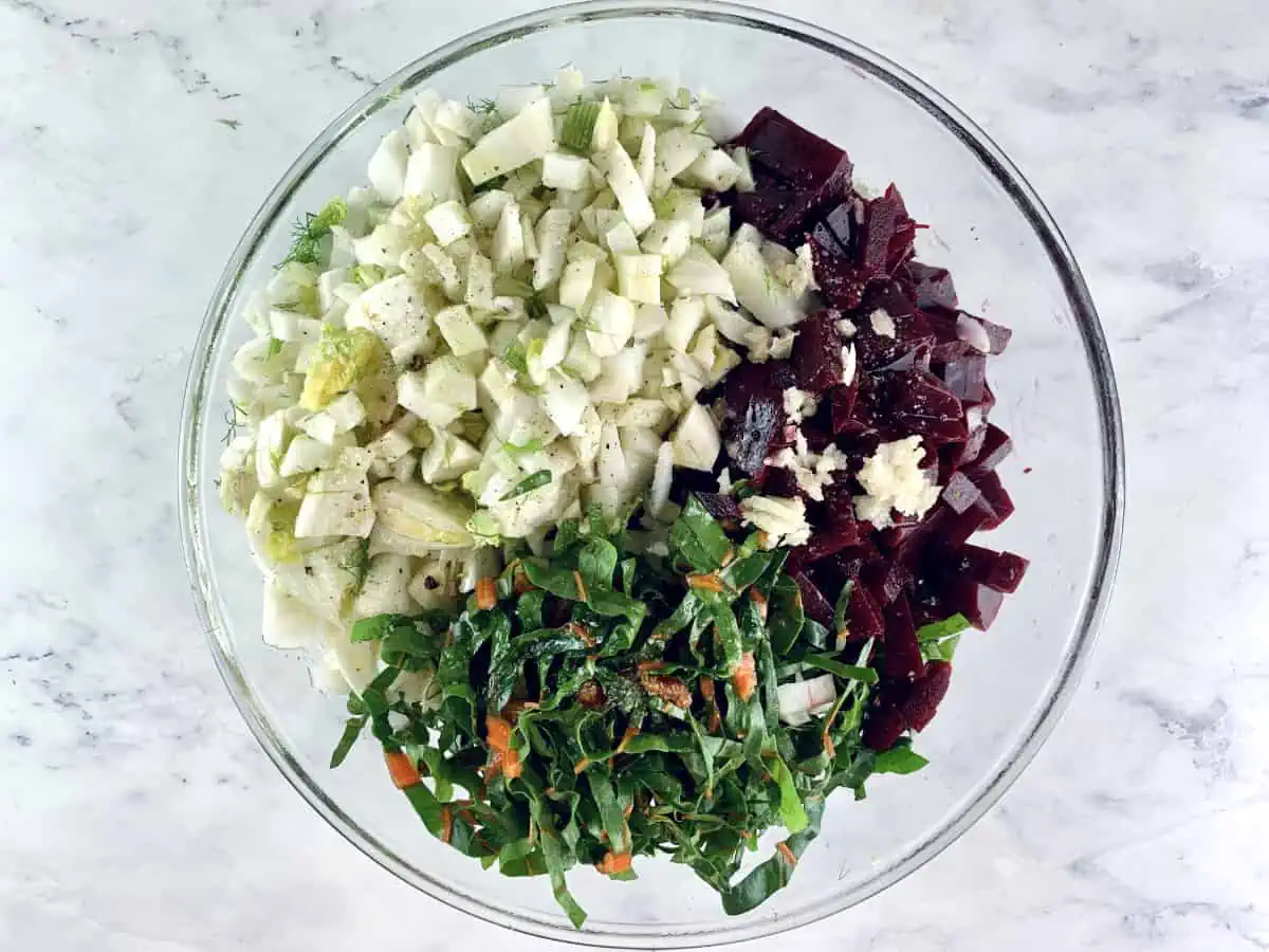 Prepared vegan beet salad ingredients in a glass bowl.
