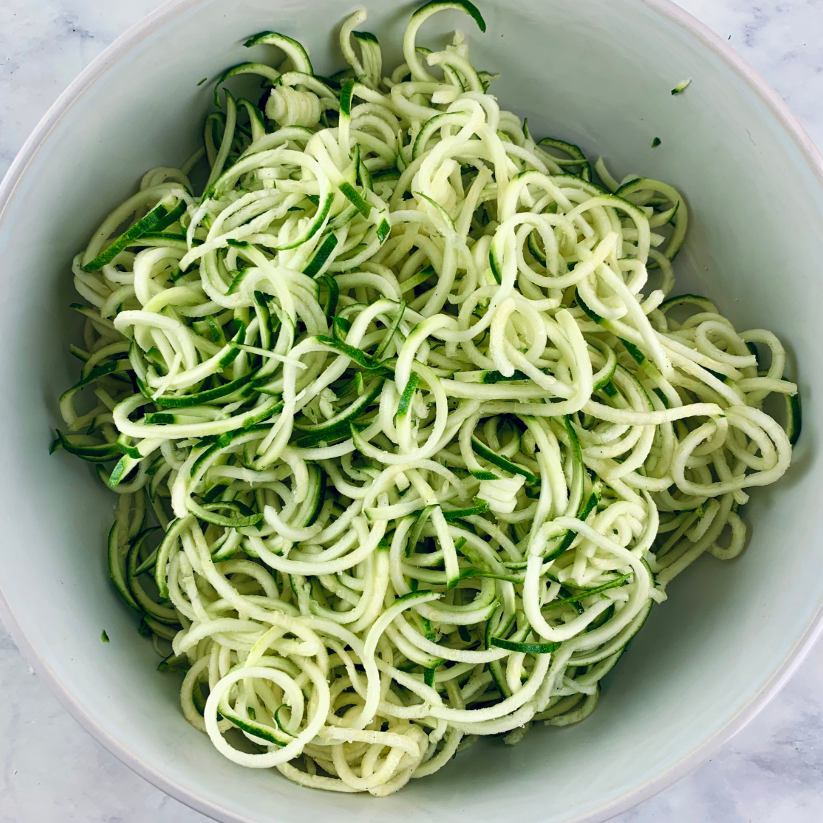 Zucchini Noodles "zoodles" in a white bowl.