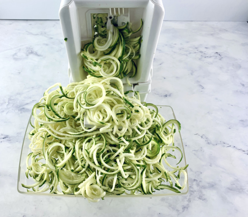 Zoodles coming out of a spiralizer.