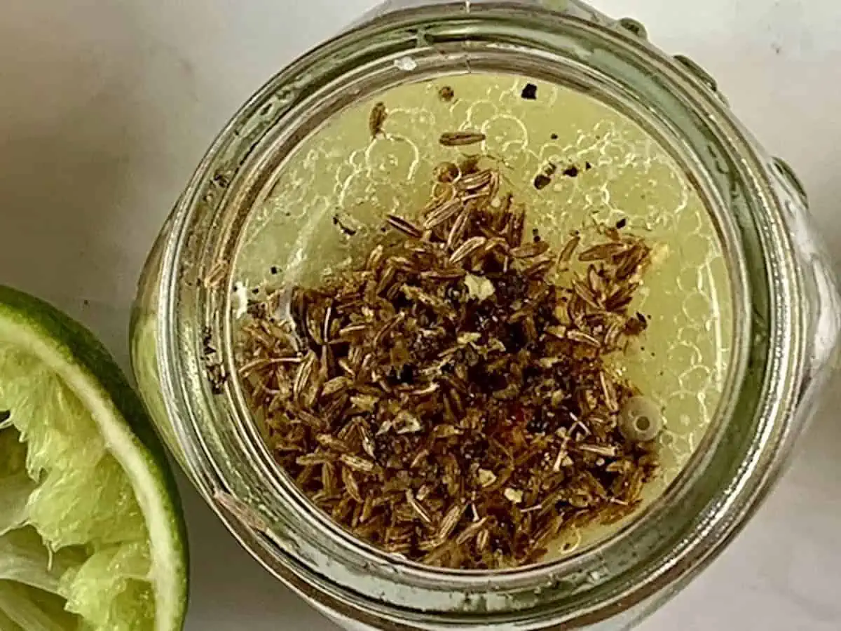 Lemon cumin dressing ingredients in a glass jar.